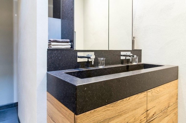Badkamer met natuurstenen wastafel en eiken meubel